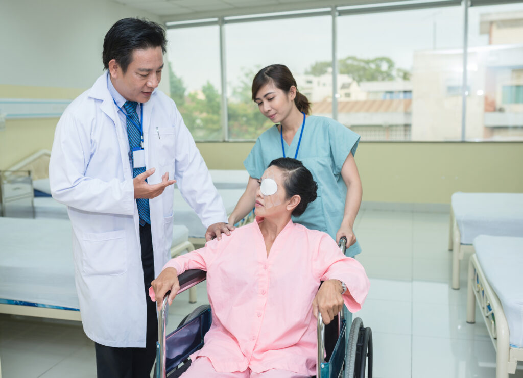 Cataract Surgery Aftercare: What to Expect and Tips for Recovery 4 Female patient being transported through a wheelchair talks to a doctor after her cataract operation