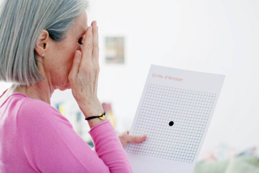 What is Age-Related Macular Degeneration? Causes, Prevention, & Treatment 8 Older woman undergoing Amsler grid as a way of diagnosing AMD