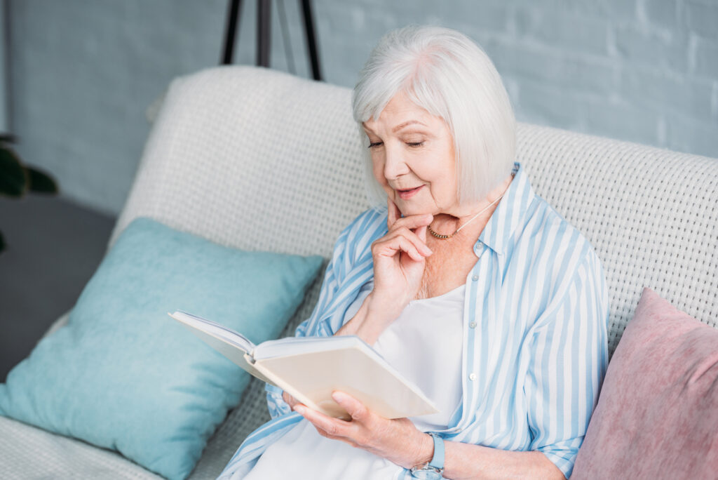 How Aging Can Change Your Vision 5 Senior woman reading book while resting on sofa at home
