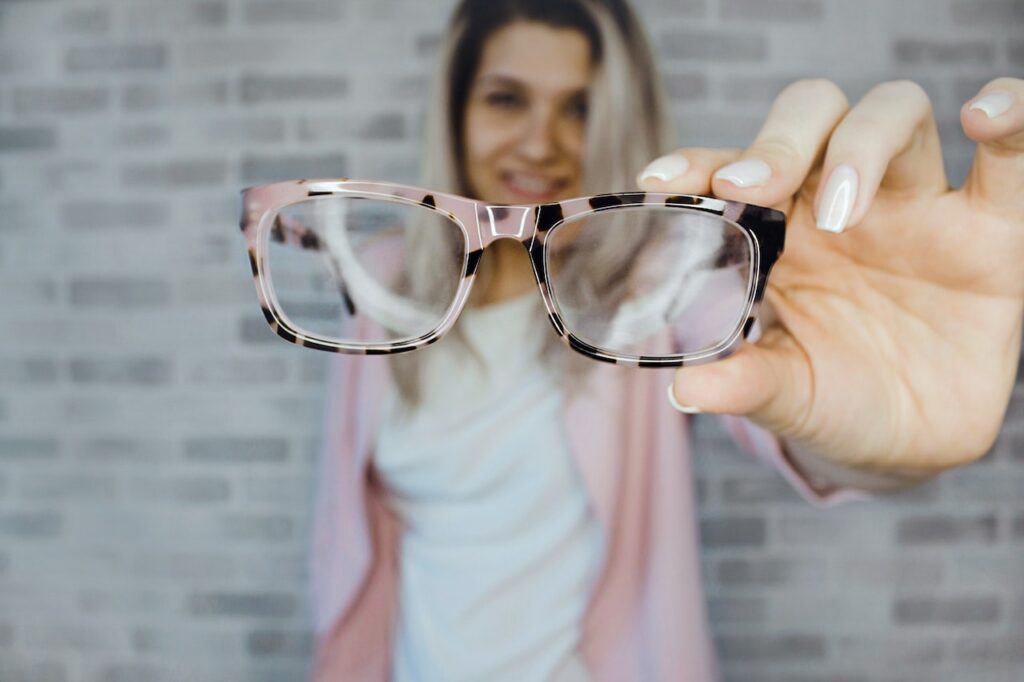 Polycarbonate Lenses 2 woman with dyed hair holding up eyeglasses to focus